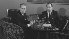 Kuva: Majuri Wayne Aho (oik) haastateltavana Suomen televisiossa (1965). Yle kuvanauha.