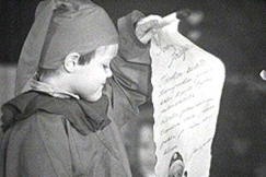 Kuva: Tontuksi pukeutunut poika lukee kirjett. YLE kuvanauha. 