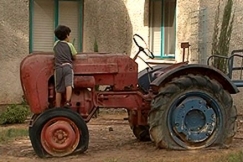 Kuva: Poika seisoo traktorin pyrll. YLE kuvanauha.