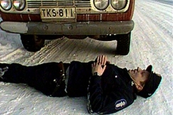 Kuva: Poliisi makaa auton edessä. YLE kuvanauha.