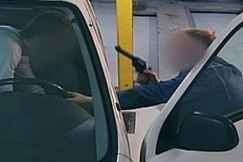 Kuva: Mies vet aseella uhaten toista miest pois autosta. YLE kuvanauha.  