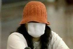 Kuva: Hengityssuojaimella varustautunut matkustaja kiinalaisella lentokentll. (2003) YLE kuvanauha.