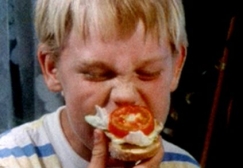 Kuva: Poika haukkaa voileip. YLE kuvanauha.