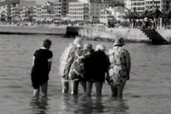 Kuva: Turistit kahlaavat rantavedess (1976). YLE kuvanauha.