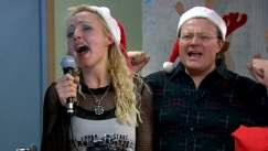 Kuva: Pivi (Mari Perankoski) ja Topi-Petteri (Kari Hietalahti) laulavat karaokea puolueen pikkujouluissa. 