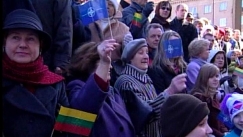 Kuva: Ihmiset heiluttavat Liettuan ja Naton lippuja Vilnassa 2004. YLE kuvanauha.