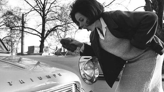 Auton keväthuolto kotikonstein. Laila Halme kiillottaa autoa v. 1964. Kuva: Kall