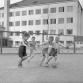 Pojat potkivat jalkapalloa koulun pihalla. Kalle Kultala, 1950-luku.