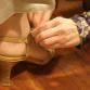 Puvustaja auttaa kenkien sovituksessa. Kuva: YLE