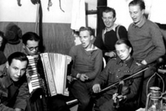 Kuva: Sotilaat musisoivat vapaa-aikanaan jatkosodan aikana It-Karjalassa. Eino Nurmi.