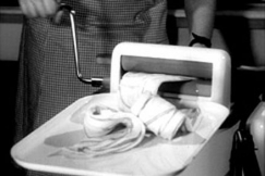 Kuva: Pyykki kuivataan pesukoneen vntpuristimella. (1955) YLE kuvanauha.