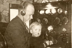 Kuva: Olli Snellman kuuntelee radiota radiolhettimen ress ja pit sylissn poikaansa Seppo Snellmania. (1930-luku) Marja-Leena Polojrvi.